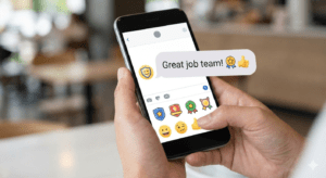 Text message praising team with emojis on smartphone
